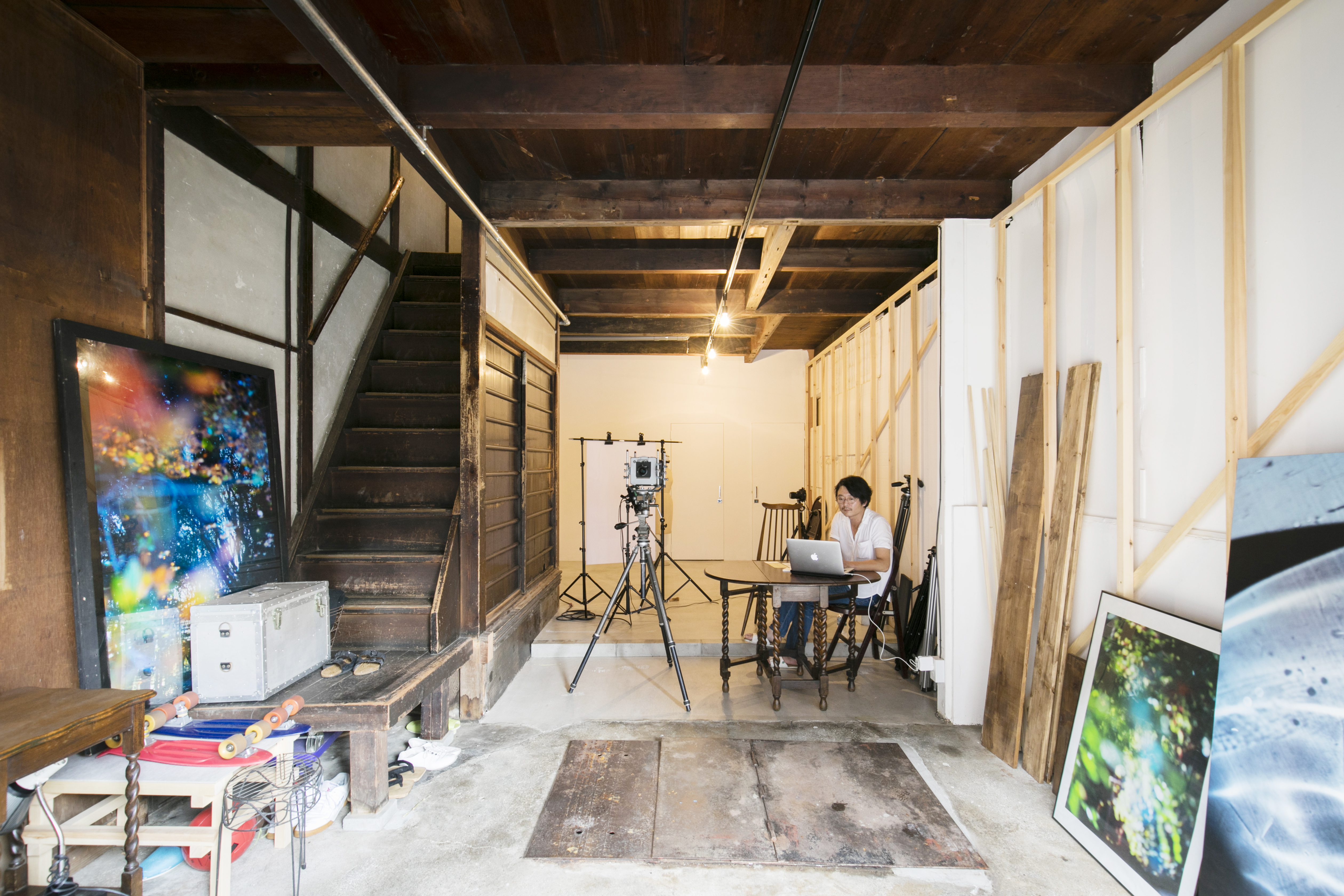入居者第１号であるカメラマンの田中陽介さん。１階はスタジオ兼ガレージとして使用中。奥の合板壁はDIYで白く塗装したそう。